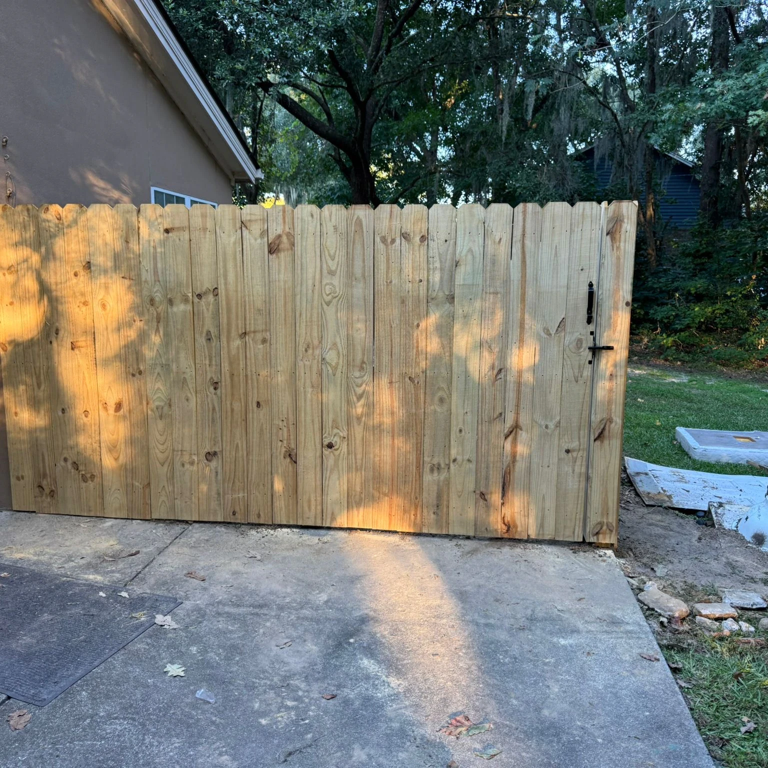 Wood privacy fence and gate beside a patio