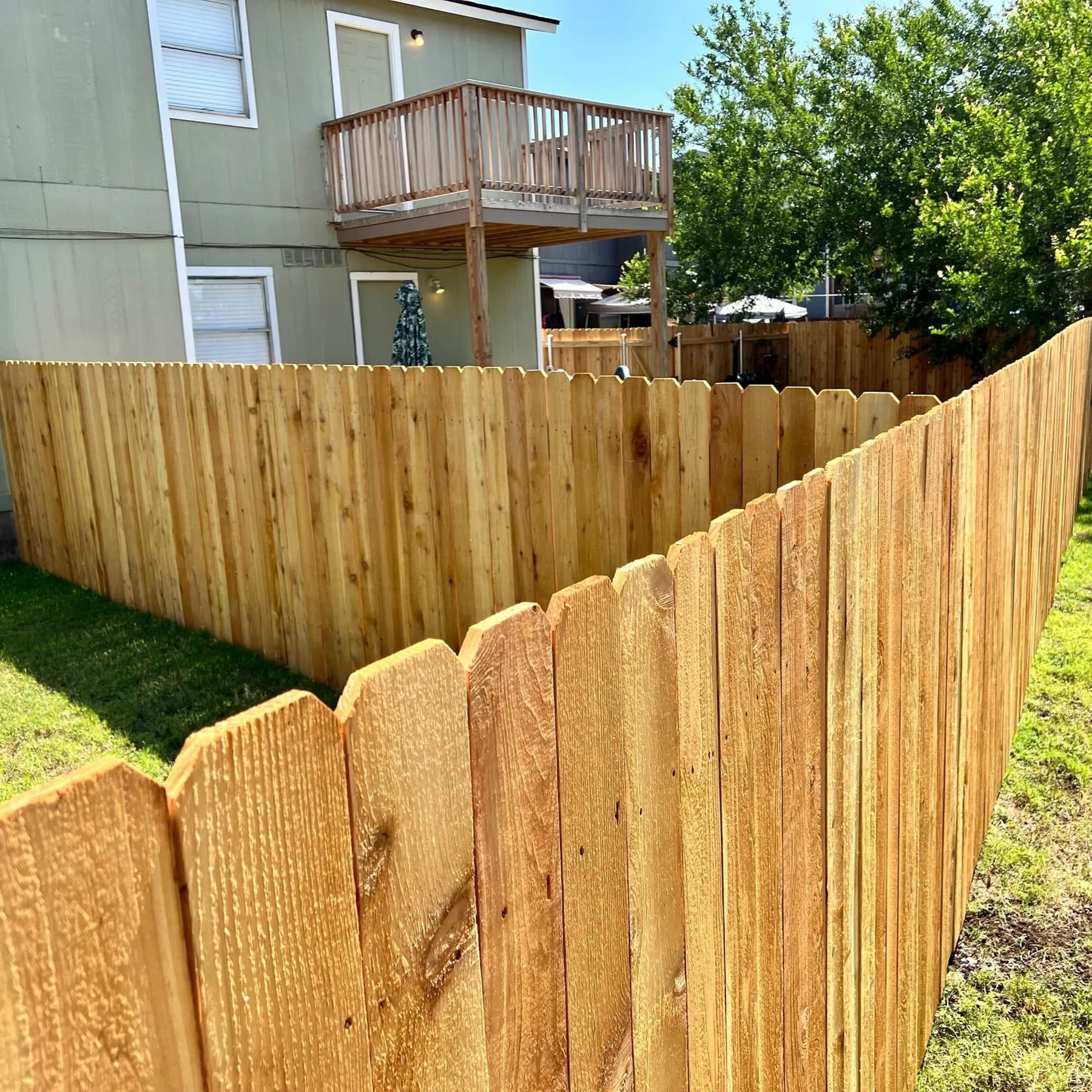 Dog-eared wood privacy fence running along the side yard of a home