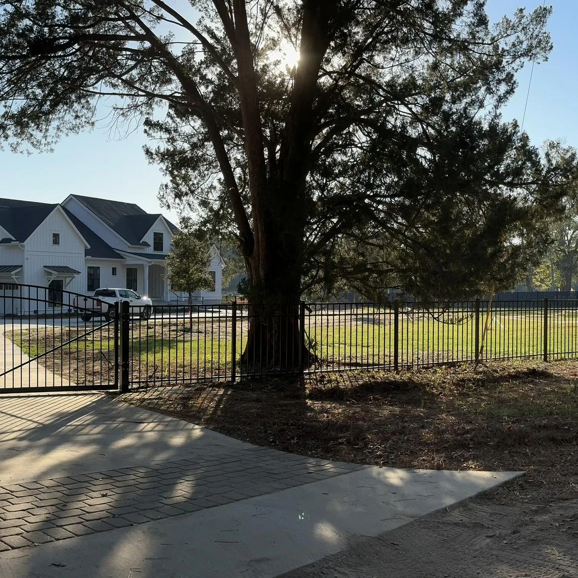 Black aluminum estate fence and driveway gate on a large lot
