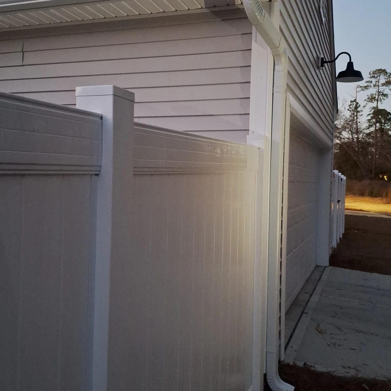 Vinyl privacy fence tied into the corner of a home